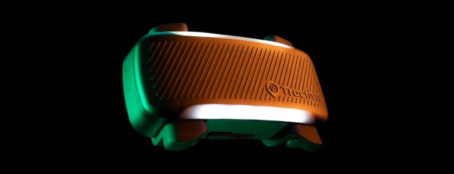 close up of the tractive GPS tracker with LED light illuminated on back background